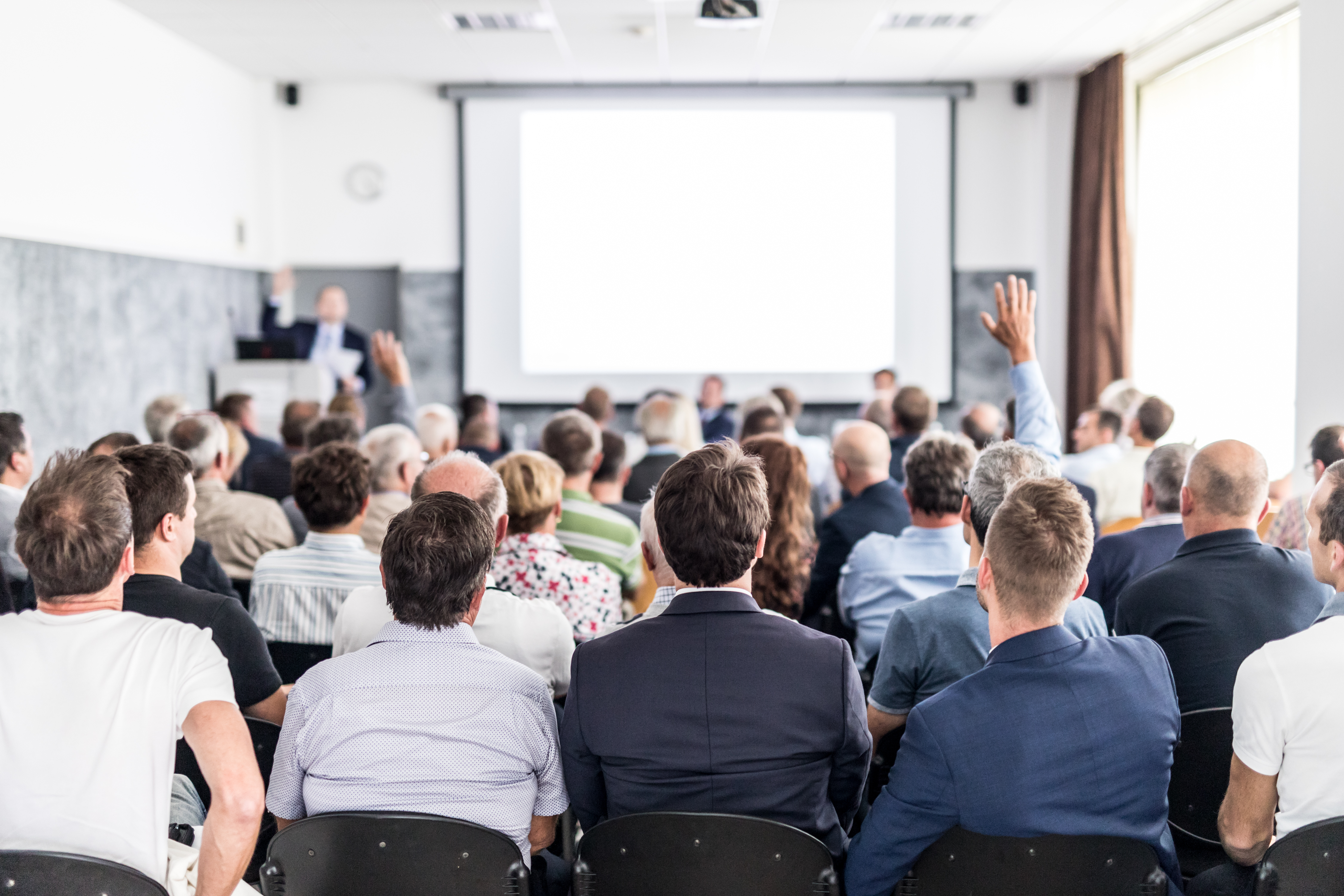 Mensen zittend in een zaal van de achterkant gefotografeerd
