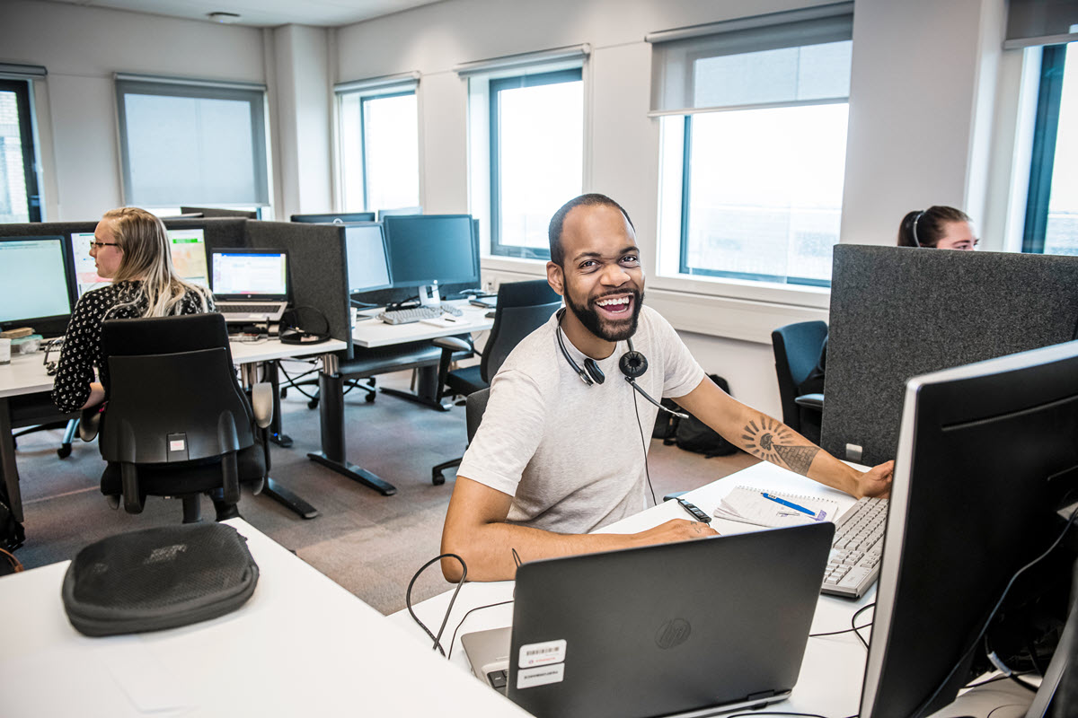 Een klantenservicemedewerker van Achmea lacht in de camera