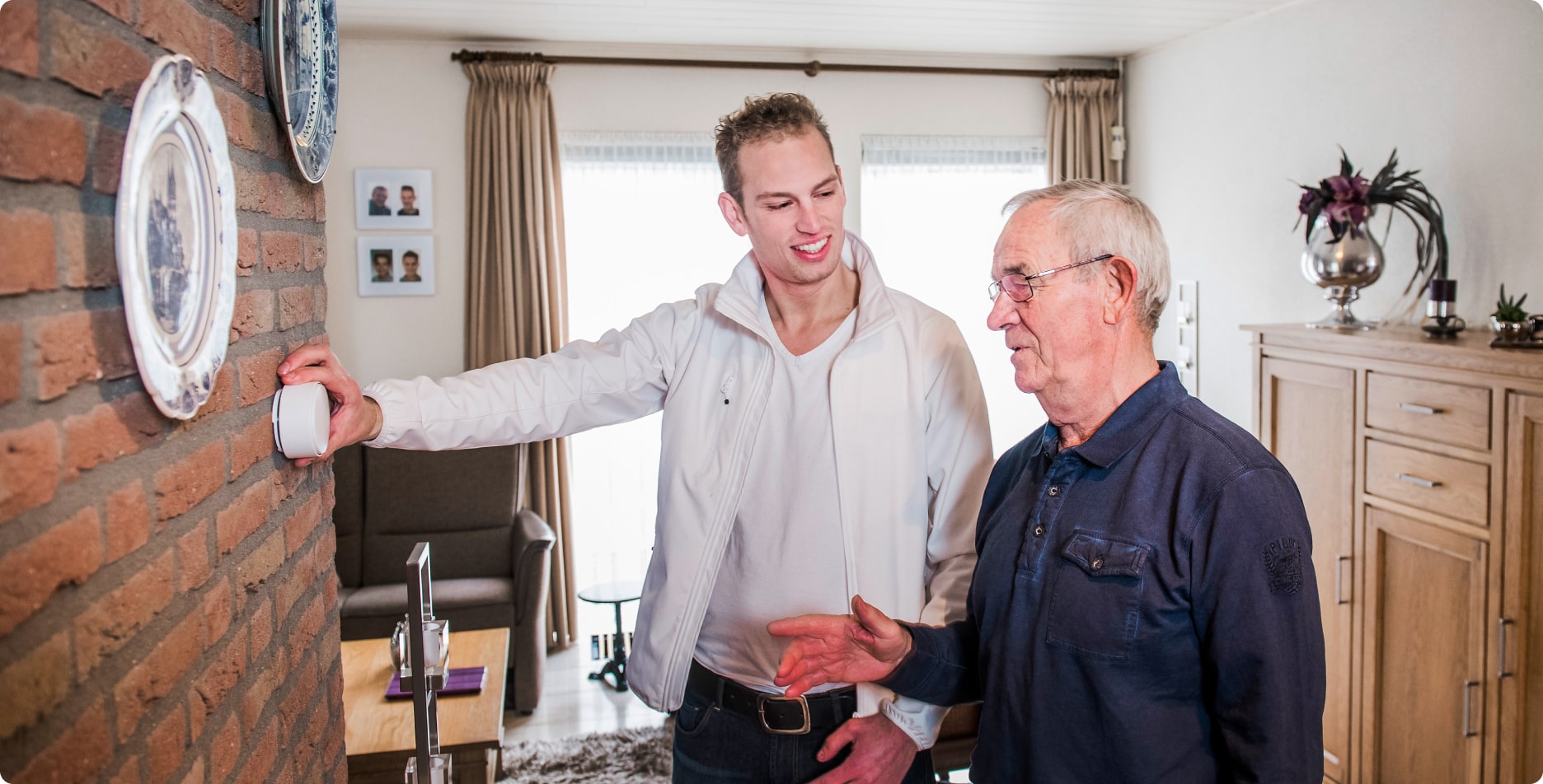 Installateur en oudere man kijken naar slimme meter die net is geïnstalleerd.