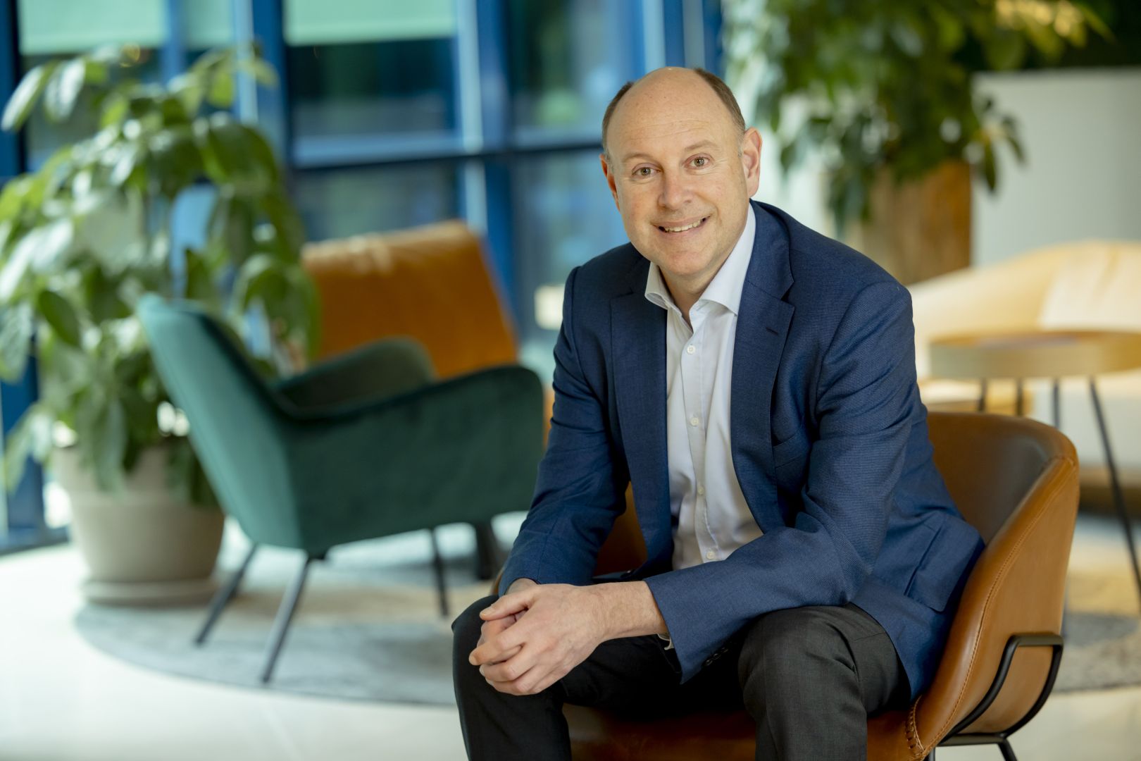 Michiel Delfos zittend in een stoel in de kantoortuin