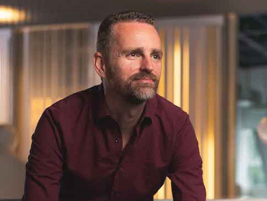 Foto van Arnoud Boere programmamanager AI bij Achmea die zit en met zijn armen leunt - Bij artikel: Mensgerichte AI - Hoe Achmea HR de toekomst van werk vormgeeft